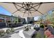 Beautifully appointed deck features an umbrella, lounge area, dining set, and a view of the backyard at 3895 Chimayo Rd, Littleton, CO 80123