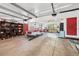 Spacious garage with concrete floors, red doors, storage, and classic red and white car on tracks at 3895 Chimayo Rd, Littleton, CO 80123