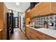 Gourmet kitchen boasts custom wood cabinets, black appliances, and a unique tile backsplash extending to the ceiling at 3895 Chimayo Rd, Littleton, CO 80123