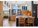 Bright kitchen featuring custom wood cabinetry, modern island with breakfast bar, and a large window for natural light at 3895 Chimayo Rd, Littleton, CO 80123