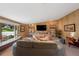 Cozy living area featuring a large window seat, wood paneling, comfortable seating, and custom built-in bookshelves at 3895 Chimayo Rd, Littleton, CO 80123