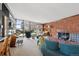 Bright living room featuring a brick fireplace, large windows, and stylish contemporary furnishings at 3895 Chimayo Rd, Littleton, CO 80123