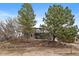 Home exterior with mature trees, a stone retaining wall, and a rustic charm at 8165 Tempest Ridge Way, Parker, CO 80134