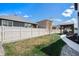 Expansive backyard with lush lawn, white fence, and a charming pergola-covered outdoor kitchen at 8852 Farmdale St, Firestone, CO 80504