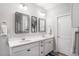 Bright bathroom featuring a double vanity with framed mirrors and white cabinetry at 8852 Farmdale St, Firestone, CO 80504