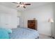 A bright bedroom with a ceiling fan, double door closet, and a wooden dresser at 8852 Farmdale St, Firestone, CO 80504