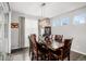 Formal dining room with a dark wood table and chairs, decorative light fixture and sliding glass door at 8852 Farmdale St, Firestone, CO 80504
