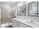 Contemporary bathroom featuring a double vanity, modern mirrors, and walk-in shower with glass door at 8852 Farmdale St, Firestone, CO 80504