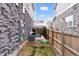 Narrow fenced yard with small patio, grass and wood chip area between houses at 21823 E 8Th Ave, Aurora, CO 80018