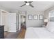 Well-lit bedroom features a ceiling fan and artwork, offering a view into an adjacent hallway at 21823 E 8Th Ave, Aurora, CO 80018