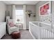 Bright Bedroom featuring a white crib, cozy armchair, and playful wall decor for a comforting space at 21823 E 8Th Ave, Aurora, CO 80018