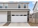 Two-car garage with white doors and gray stone and vinyl siding at 21823 E 8Th Ave, Aurora, CO 80018