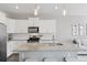 Modern kitchen boasts white cabinetry, stainless steel appliances, and a granite-topped island with seating at 21823 E 8Th Ave, Aurora, CO 80018
