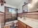 Well-lit bathroom featuring stylish tiling, a glass-enclosed shower, and a modern vanity at 2220 W 73Rd Pl, Denver, CO 80221