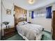 Comfortable bedroom with a decorative wooden headboard and charming blue curtains at 2220 W 73Rd Pl, Denver, CO 80221