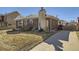 Brick home featuring a stone chimney, well-maintained lawn, and private driveway at 2220 W 73Rd Pl, Denver, CO 80221
