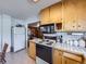 Bright kitchen with white appliances, tile countertops, and light wood cabinets and floors at 2220 W 73Rd Pl, Denver, CO 80221
