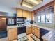 Traditional kitchen featuring light wood cabinetry, tile countertops and backsplash, and modern appliances at 2220 W 73Rd Pl, Denver, CO 80221