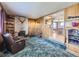 Spacious living room with brick fireplace, plush carpeting, and an open view to the adjacent kitchen at 2220 W 73Rd Pl, Denver, CO 80221