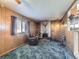 Cozy living room boasts a brick fireplace, wood paneling, and plush carpeting for a warm ambiance at 2220 W 73Rd Pl, Denver, CO 80221