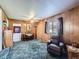 Relaxing living room featuring wood paneling, plush carpet, and comfortable seating at 2220 W 73Rd Pl, Denver, CO 80221