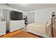 Bedroom with a bed, large dresser, television, and wood flooring with an area rug at 1070 S Newton St, Denver, CO 80219
