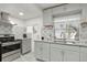Bright kitchen features gray cabinets, granite countertops, mosaic backsplash, and stainless steel appliances at 1070 S Newton St, Denver, CO 80219