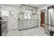 The kitchen has gray cabinets, stainless steel appliances, gray tile floors, and bright lighting at 1070 S Newton St, Denver, CO 80219