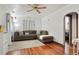 Comfortable living room features a large sectional sofa, ceiling fan, hardwood floors, and arched doorway at 1070 S Newton St, Denver, CO 80219