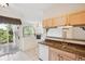 Kitchen with granite counters, wood cabinetry, open layout, and balcony access; ideal for indoor/outdoor living at 1878 S Cole St, Lakewood, CO 80228