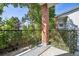 Patio with a decorative brick pillar and wrought iron railing with natural tree views at 1878 S Cole St, Lakewood, CO 80228