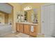 Bathroom features a vanity with a large mirror and warm color palette, plus a door leading to other areas at 9536 W Avalon Dr, Littleton, CO 80127