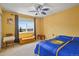 Bedroom featuring large window with scenic views, ceiling fan, and sports team decor at 9536 W Avalon Dr, Littleton, CO 80127