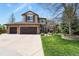 Beautiful two-story home featuring a three-car garage, stone accents, lush lawn, and mature trees at 9536 W Avalon Dr, Littleton, CO 80127