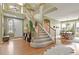 Bright foyer features hardwood floors, a staircase, and a view into the dining room at 9536 W Avalon Dr, Littleton, CO 80127