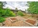 Spacious backyard with garden beds, lush landscaping, and a charming home exterior at 1607 Ulysses St, Golden, CO 80401