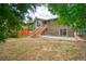 Spacious backyard with lush greenery and wooden stairs leading to the deck at 1607 Ulysses St, Golden, CO 80401