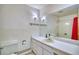 Bathroom with tile walls, white vanity, large mirror, and red shower curtain at 1607 Ulysses St, Golden, CO 80401
