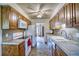 Galley kitchen featuring wooden cabinets, white appliances, and tile countertops and backsplash at 1607 Ulysses St, Golden, CO 80401