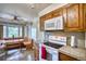 Eat-in kitchen featuring a built-in bench, oak cabinets, and white appliances at 1607 Ulysses St, Golden, CO 80401