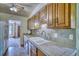 Kitchen featuring wood cabinets, double basin sink, tile counters, and views to a living area at 1607 Ulysses St, Golden, CO 80401