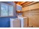 Practical laundry area with washer, dryer, and storage shelf at 1607 Ulysses St, Golden, CO 80401