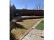 Backyard view with stone patio, artificial turf, low garden wall, and wood fence at 17910 E 54Th Ave, Denver, CO 80249