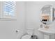 Clean half bath with pedestal sink, toilet, and shuttered window at 8353 Bijou Creek Ave, Littleton, CO 80125