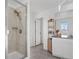 Modern bathroom boasting glass enclosed shower with rainfall shower head, granite counters, and stylish shelving unit at 8353 Bijou Creek Ave, Littleton, CO 80125