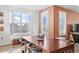 Bright dining room with wood floors, large windows with shutters, and table for entertaining at 8353 Bijou Creek Ave, Littleton, CO 80125