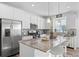 Modern kitchen with stainless steel appliances, granite countertops, island with bar seating, and white cabinetry at 8353 Bijou Creek Ave, Littleton, CO 80125