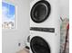 Modern laundry room featuring stacked washer and dryer, and a window letting in natural light at 8353 Bijou Creek Ave, Littleton, CO 80125