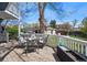 Outdoor deck area features a charming dining set, white railing, and lush backyard views at 2244 Fenton St, Edgewater, CO 80214