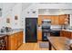 View of kitchen area features black appliances and warm oak cabinets at 2244 Fenton St, Edgewater, CO 80214
